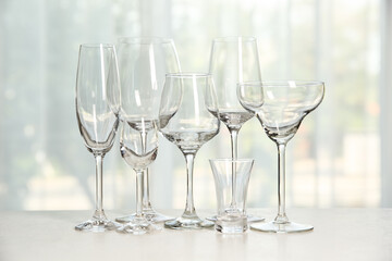 Different elegant empty glasses on grey table indoors