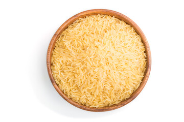 Wooden bowl with raw golden rice isolated on white background. Top view.