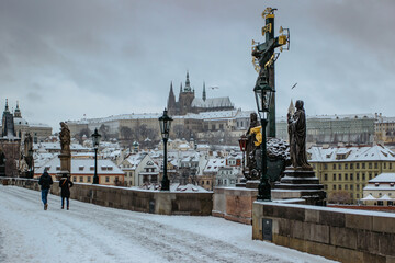 Fototapeta premium Postcard view of Prague Castle from Charles Bridge, Czech republic.Famous tourist destination.Prague winter panorama.Snowy day in the city.Amazing European cityscape cold weather.Romantic atmosphere