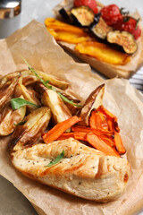 Delicious cooked chicken and vegetables on table, closeup. Healthy meals from air fryer