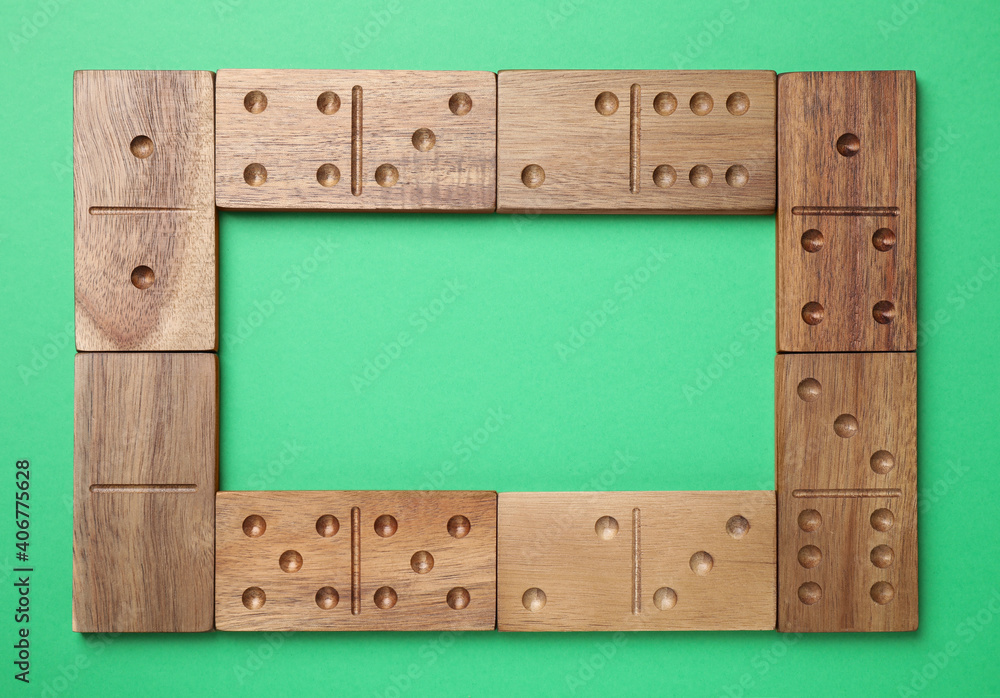 Canvas Prints Frame made of wooden domino tiles on green background, flat lay. Space for text