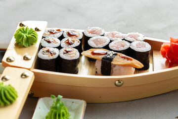 Set of maki sushi on wooden boat tray