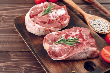 Raw meat beef shank slices on brown wooden board