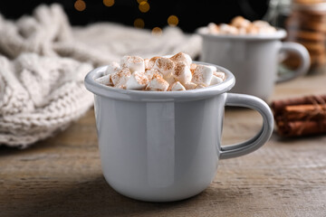 Cup of hot drink with marshmallows on wooden table