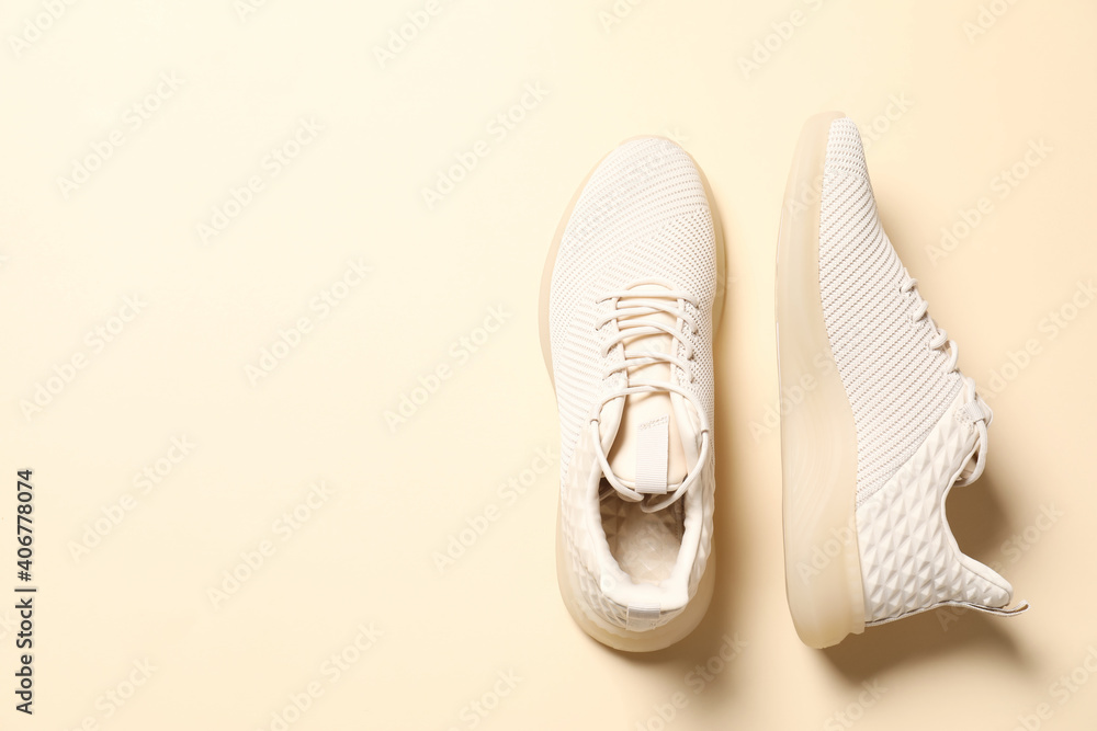 Sticker Pair of stylish sport shoes on beige background, flat lay. Space for text