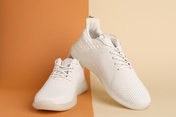 Pair of stylish sport shoes on color background