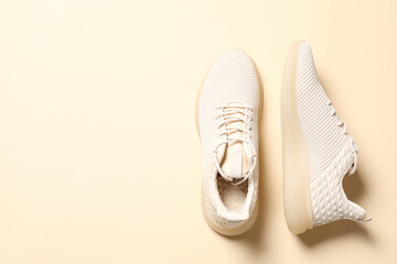 Pair of stylish sport shoes on beige background, flat lay. Space for text