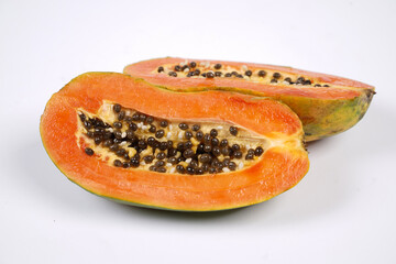 Whole Papaya fruit with a few slices isolated on a bright background. Close-up of juicy and...