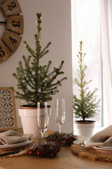 Small potted fir trees in dining room. Interior design