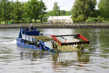 MINSK, BELARUS - 1 OCTOBER, 2020: mowing algae in the river in the city