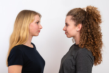 two females standing face each other, isolated on white background