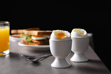 Soft boiled eggs served on grey table. Space for text
