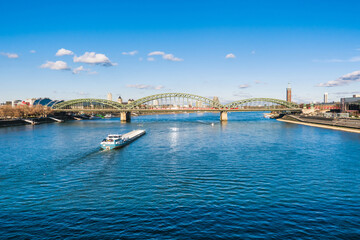 Obraz premium Cologne Koln Köln, Germany, Panorama view of the Rhine River with Hohenzollernbrücke, Cargo Ship and Blue Sky