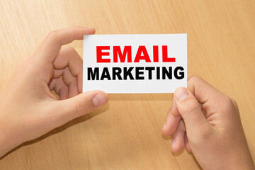 Card with text EMAIL MARKETING on hands. You can use in business, marketing and other concepts. Messege of the day.