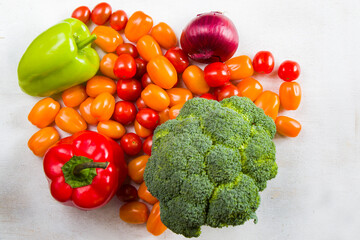 Cherry tomatoes, red and green bell pepper and broccoli on the white background