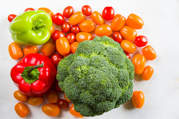 Cherry tomatoes, red and green bell pepper and broccoli on the white background