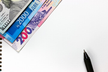 dollars, rubles and hryvnia - on a notebook with a pen, copy spaсe	