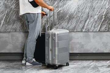 Casual unrecognizable man standing with luggage suitcase