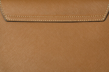 Brown saffiano leather stitched with a seam. Real or genuine leather texture background.