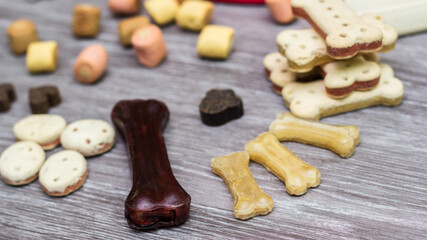 Pet food, snacks for dogs. Dog tasty colored biscuits on wooden background