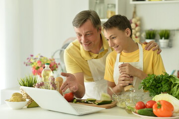 Portrait of man and boy cooking in kitchen