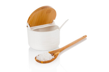 Sea salt in wooden spoon and ceramic salt container isolated on white background