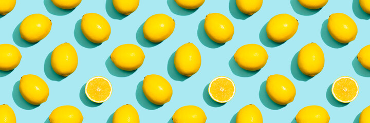 Lemons pattern on a blue background. Whole and half lemons top view.