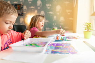 children paint with watercolors at home. creative young artist at work