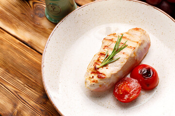 Grilled chicken breast served with cherry tomatoes on table
