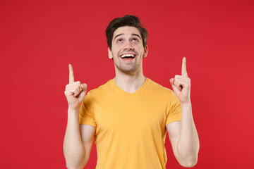 Young smiling unshaved caucasian man 20s in casual blank print design yellow t-shirt point index...