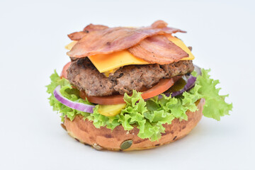 burger with melted cheese, ham, tomatoes and fried onions