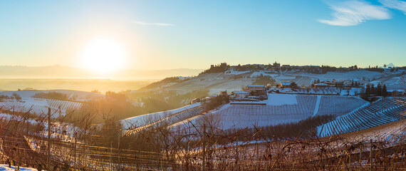 Italy Piedmont: Barolo wine yards unique landscape winter sunset, Novello medieval village castle on hill top, the Alps snow capped mountains background, italian historical heritage grape agriculture
