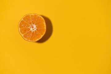 Half cut clementine tangerine isolated on orange color background. Copy space.