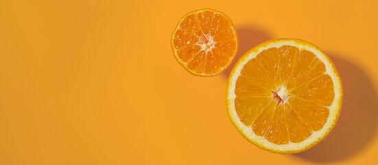 Half cut orange and clementine tangerine isolated on color background. Copy space.