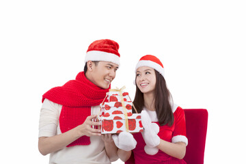Portrait of young couple wearing Santa hats,holding gift