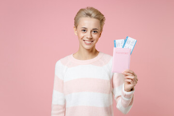 Traveler tourist woman in casual sweater dental braces short haircut hold passport tickets isolated on pastel pink background Passenger traveling abroad on weekends getaway Air flight journey concept