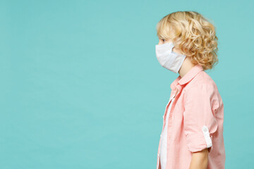 Side view of little kid boy in pink shirt sterile face mask safe from coronavirus virus covid-19...