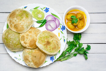 Traditional Bengali cuisine - Green peas kachori or Koraishutir kochuri in a ceramic plate .