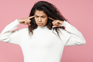 Young irritated naughty african american woman 20s curly hair in white knitted sweater look camera...