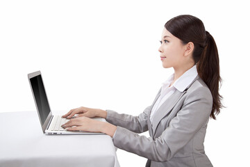 Portrait of young businesswoman sitting in front of laptop,side view