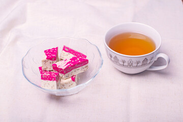 Cherry halva dessert slices on the table with a cup of tea.