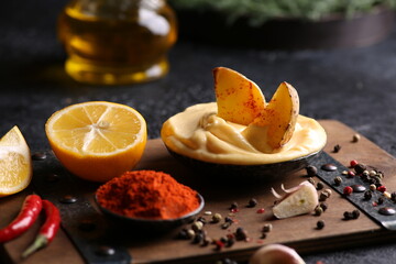 Snacks. Rustic potatoes with mayonnaise sauce in bowl, spices, paprika, lemon, garlic and chili pepper. Olive oil and herbs on a wooden background. Background image, copy space, horizontal