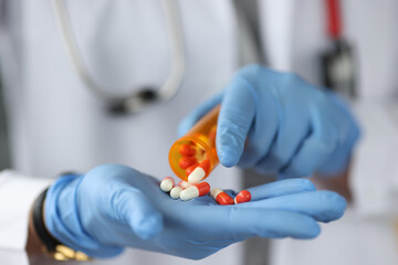 Doctor sprinkles the pills on gloved hand