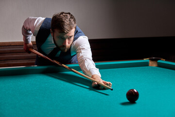 Fototapeta premium man holding arm on billiard table, playing snooker game or preparing aiming to shoot pool balls. sport game snooker billiards
