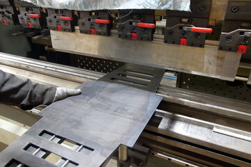 process of steel bending by worker on metal bending machine