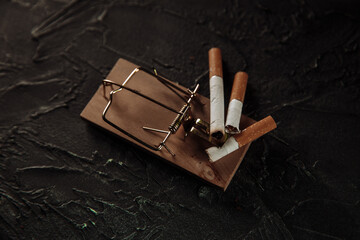 Cigarettes on a mouse trap. Dangerous addiction concept.