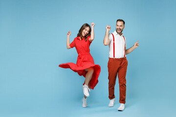 Full length of cheerful young couple friends man woman in white red clothes dancing point fingers...