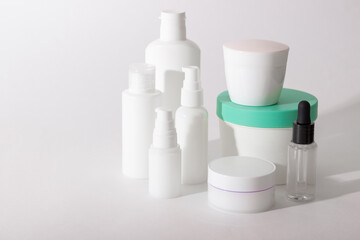 Set of white cosmetic bottles and jars with hard shadows. Home and beauty salon care concept