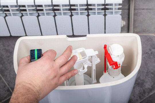 Studio lighting. bathroom. Toilet bowl. The housewife adds a special cleaning and disinfection agent to the barrels.