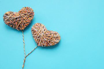 hearts are linked from multi-colored thread on blue background, valentine's day, flat lay, copy space